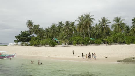 Imágenes-Aéreas-De-Drones-De-4k-De-Amigos-Jugando-Con-Una-Tabla-De-Boogie-En-La-Playa-En-La-Paradisíaca-Isla-Tropical-De-Siargao,-Filipinas