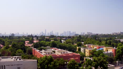 Revelando-La-Ciudad-Detrás-De-Una-Palmera-Sobre-Los-Suburbios-Se-Encuentra-Una-Gran-Ciudad-Metropolitana,-Tel-Aviv.