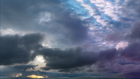 Die-Wunderschönen-Farben-Des-Himmels-Mit-Wolken,-Die-über-Uns-Hinwegrollen-Und-Dahinrasen-Und-Der-Sonne,-Die-Sich-Dahinter-Verbirgt---Zeitraffer