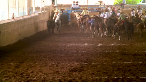 Charros,-Mexican-cowboys-performing-tricks-during-a-Charreada,-a-horse-rider-competition