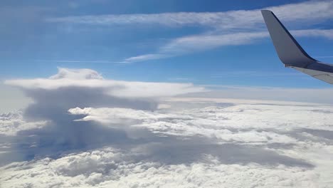 Blick-Aus-Dem-Fenster-Eines-Flugzeugs-Auf-Wolken-Mit-Cumulonimbus-An-Einem-Sonnigen-Tag