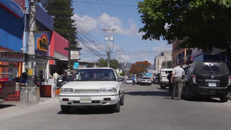 A-small-street-in-Tegucigalpa,-Honduras-with-cars-passing-on-either-side