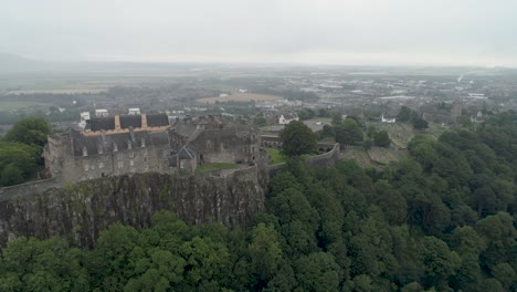 Empuje-Aéreo-En-Toma-Del-Castillo-De-Stirling,-Volando-Al-Noreste-Sobre-Los-árboles-En-Un-Día-Nublado