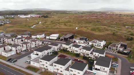 Areal-shot-of-residential-neighbourhood-in-middle-of-nature-and-lava-rocks-in-Iceland