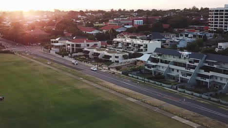 Antena,-Drone-En-Toma-Volando-Sobre-El-Parque-Y-Casas-Cercanas-Y-Zona-Residencial-Al-Amanecer