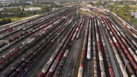 Toma-Aérea-Que-Muestra-Un-Gran-Depósito-De-Trenes-Con-Muchos-Trenes-De-Carga-Coloridos