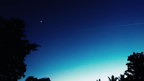 Contrail-against-beautiful-night-sky-with-moon