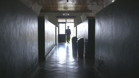 Young-lady-walking-to-an-exit-in-a-Hospital-in-Rwanda,-Africa