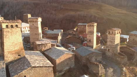 Aerial-orbit-clip-around-a-group-of-Svan-Towers-built-in-the-centre-of-a-rural-village-in-the-Svaneti-region,-Georgia