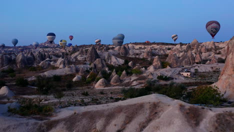 Dawn-flight-of-dozens-of-hot-air-balloons-over-the-landscape-of-Goreme-Cappadocia