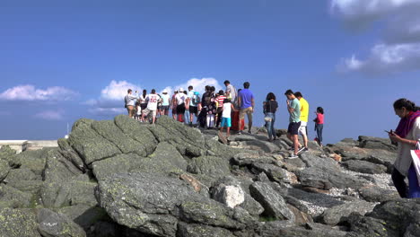 Conway,-New-Hampshire---July-4-2019:-A-line-of-tourists-waiting-to-taking-selfies-on-the-summit-of-Mount-Washington-in-Conway,-New-Hampshire-on-July-4,-2019