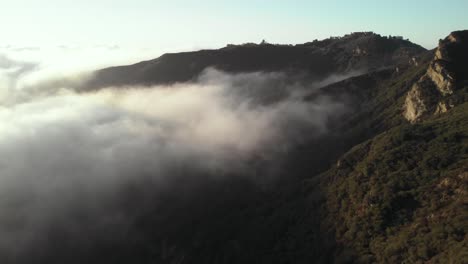 Eine-Luftaufnahme-Des-Topanga-Canyon-In-Malibu-In-Kalifornien-Mit-Den-Wolken,-Die-Sich-Am-Frühen-Morgen-Langsam-Durch-Die-Hügel-Bewegen,-Wenn-Die-Sonne-Aufgeht