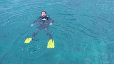 Close-up-of-scuba-diver-floating-on-his-back-in-calm-blue-sea-in-summer-Lanzarote-Spain