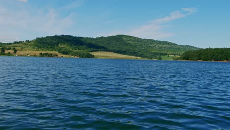 Blaues-Meerwasser-Mit-Kleinen-Wellen-Beim-Stehen-Auf-Einem-Fahrenden-Boot-Vor-Dem-Hintergrund-Der-Wunderschönen-Natur