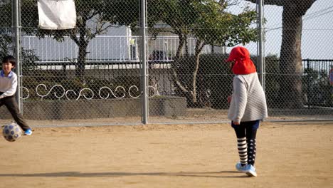 Niños-Jugando-Al-Fútbol-En-El-Patio-De-Recreo