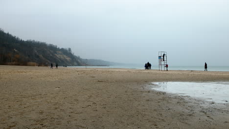 People-enjoying-overcast-Christmas-day-at-the-beach-at-Scarborough-Bluffs,-Toronto,-Canada