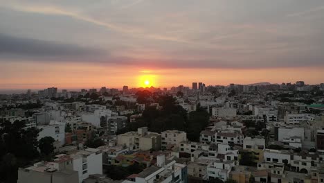 Aerial-view-revealing-the-sunset-from-the-city-in-Lima,-Peru