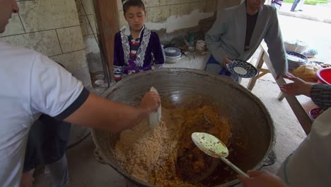 Local-Uzbek-in-Samarkand,-Uzbekistan-are-preparing-Uzbek-pilav-or-plov,-a-national-dish-of-Uzbekistan-and-a-rice-dish-common-for-people-of-Central-Asia