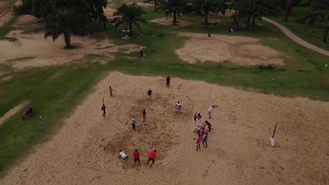 Group-of-dark-skinned-people-playing-beach-volleyball-in-Abuja-City-Park,-Nigeria