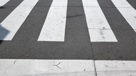 Heranzoomen-Auf-Den-Fuß-Von-Menschen-Mit-Blick-Auf-Die-Straße,-Die-Sich-Kreuzt.-Viele-Menschen-überqueren-Tagsüber-Die-Straße-Im-Stadtzentrum-Von-Tokio,-Japan-–-Kurzes-4K-UHD-Videofilmmaterial