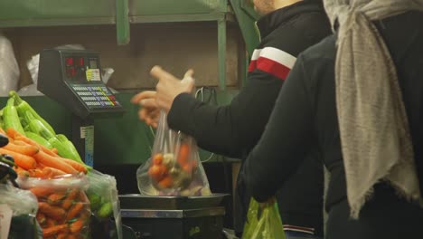 Comerciante-Pesando-Y-Vendiendo-Bolsas-De-Fruta-A-Una-Mujer-En-El-Bazar-Tajrish-En-Teherán,-Irán