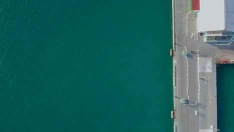 Aerial-overview-of-the-blue-water-and-the-camera-tilting-up-to-se-two-jet-skies-sailing-close-to-the-cruise-ship-4K