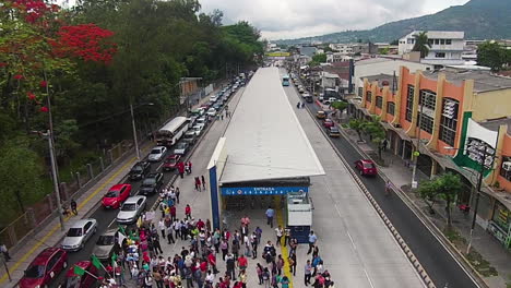 Reversal-overhead-aerial-shot-over-a-large-group-of-protesters-on-the-streets-of-a-busy-city