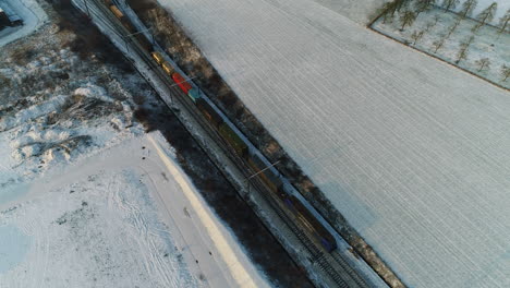 AERIAL:-A-freight-train-rides-through-a-snowy-landscape-at-low-speed