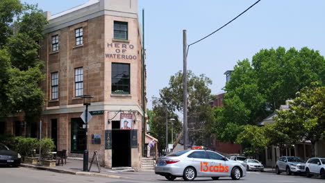 Taxicab-Drives-By-The-Hero-Of-Waterloo-Pub-The-Rocks-Sydney,-Australia