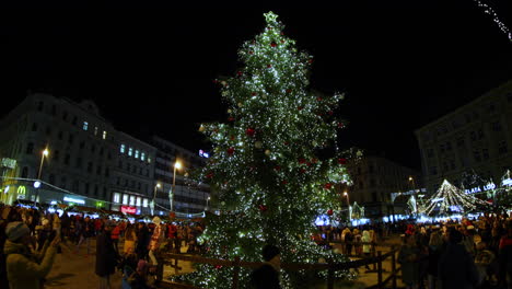 Weihnachtsbaum-In-Der-Mitte-Des-Platzes-Im-Stadtzentrum-Von-Brünn-Und-Menschenmassen-Mit-Kindern-Zwischen-Imbissständen-Und-Souvenirs,-Aufgenommen-In-4K-60fps-Zeitlupe