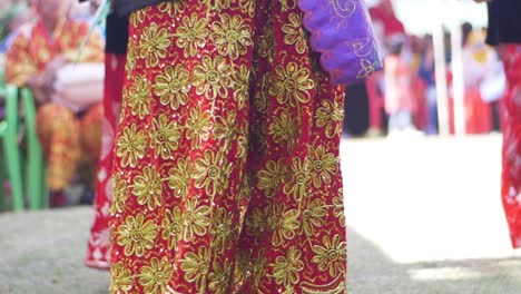 Mujeres-Vestidas-Con-Ropa-Colorida-Y-Muy-Decorada-Realizan-Un-Baile-Cultural-Con-Fanáticos-Mientras-Otras-Damas-Observan-Durante-Una-Celebración.