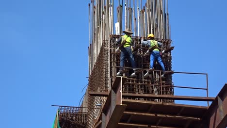 Bauarbeiter,-Die-In-Der-Höhe-Arbeiten-Und-Auf-Der-Baustelle-Stahlbewehrungsstäbe-Herstellen