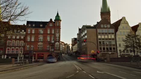 Zoom-out-time-lapse-of-a-busy-intersection-in-Lübeck,-Germany,-with-St