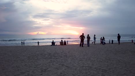 Silueta-De-Turistas-Y-Lugareños-Disfrutando-De-La-Puesta-De-Sol-Amarilla-En-La-Playa-De-Kuta-Bali-Asia-En-Medio-De-Las-Restricciones-De-Viaje-Del-Virus-Corona-Covid-19