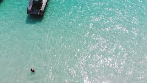 Un-Turista-Saltando-En-El-Océano-Mientras-Pasa-Una-Ola-En-La-Isla-Redang,-Malasia