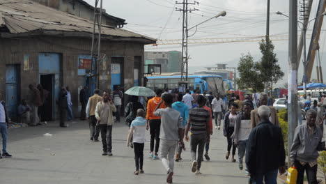 Crowd-of-people-walking-in-slow-motion-on-street-in-Addis-Ababa,-Ethiopia-during-rush-hours