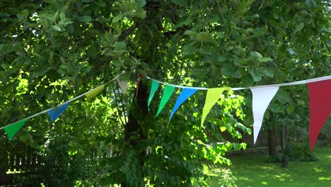 Coloridas-Banderas-De-Fiesta-En-El-Jardín-Del-Patio-De-Casa