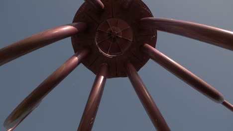 Walking-under-the-steel-octopus-sculpture-of-the-main-entrance-of-Pacific-Park,-Santa-Monica