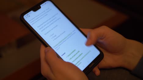 Closeup-Of-A-Young-Woman-Reading-News-About-Coronavirus-On-Her-Smartphone