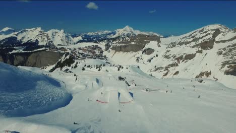 Una-Toma-Aérea-De-Un-Snowboarder-Realiza-Un-Salto-En-El-Parque-De-Nieve-De-Avoriaz,-En-Los-Alpes-De-Francia.