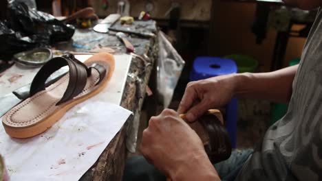 Handwerker-Bei-Der-Manuellen-Herstellung-Von-Ledersandalen-In-Seiner-Garage,-Batang,-Indonesien