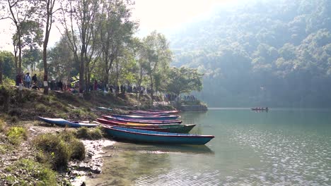 Pedestal-shot-of-paddle-boats-parked-at-the-shore-of-Fewa-Lake