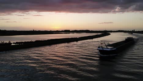 Barcaza-Vacía-Navegando-En-Un-Río-Holandés-Durante-La-Puesta-De-Sol