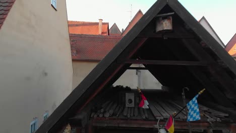 a-drone-flies-close-and-passes-through-the-roof-of-a-small-barn-in-the-neighboring-yard