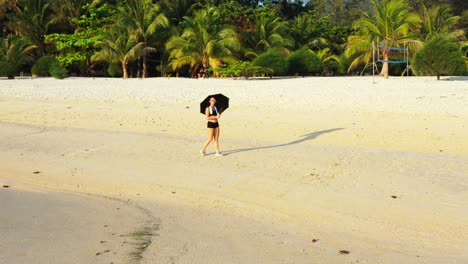 Ruhiger-Exotischer-Strand-Mit-Weißem-Sand-Und-Palmen,-An-Dem-Junge-Frauen-Mit-Sonnenschirm-An-Einem-Sonnigen-Urlaubstag-Auf-Fidschi-Spazieren-Gehen