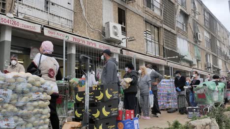 People-lining-up-in-queue-to-shop-on-Tel-Aviv,-Israel-street,-coronavirus-pandemic