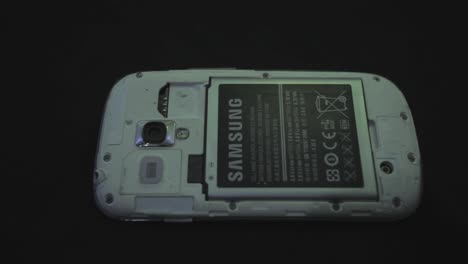 Installing-A-New-Battery-At-The-Back-Of-An-Old-White-Samsung-Mobile-Phone---Closeup-Shot