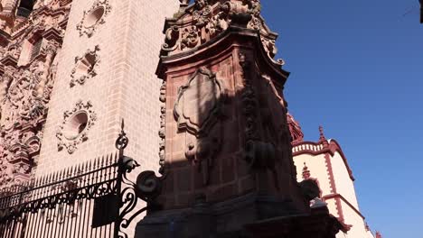 Vista-Exterior-Del-Lado-Derecho-De-La-Catedral-De-Tasco-En-México,-El-Lado-Derecho-Conduce-A-Un-Restaurante-Y-Algunas-Pequeñas-Tiendas-Con-Arte-Y-Telas-Artesanales.