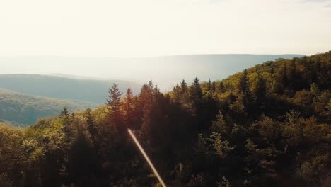 Drone-Flying-Past-Young-Man-Standing-On-Rock-At-Edge-Of-Mountain-With-Beautiful-View,-Cinematic-4K-Aerial