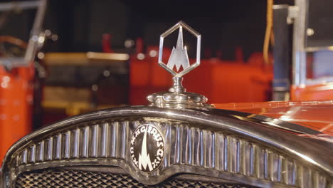 Hood-ornament,-the-logo-of-a-stylised-M-with-a-sharp,-long-centre-point-of-a-Magirus-red-fire-fighting-vehicle